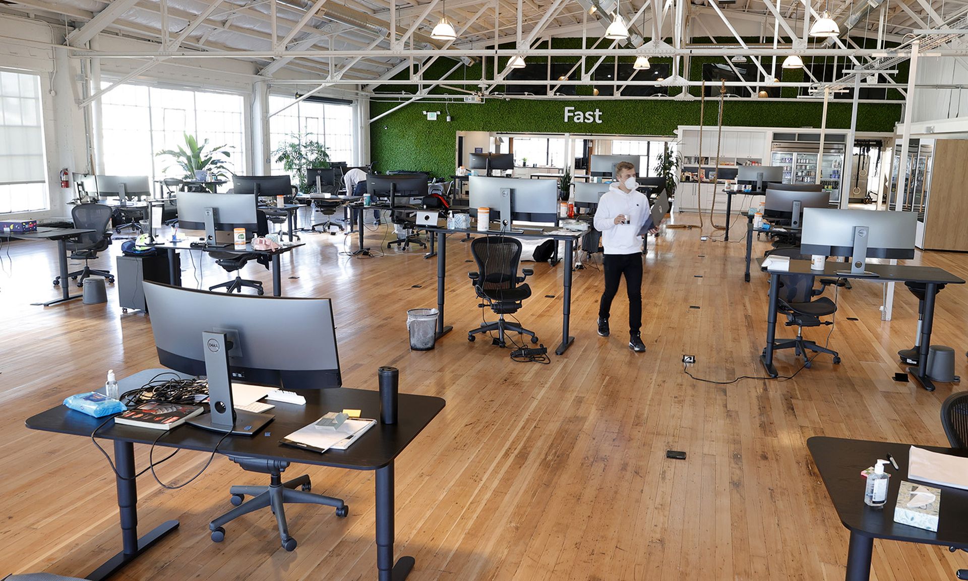 An employee at a tech startup walks by socially distanced desks in the office on March 24, 2021, in San Francisco. (Photo by Justin Sullivan/Getty Images)