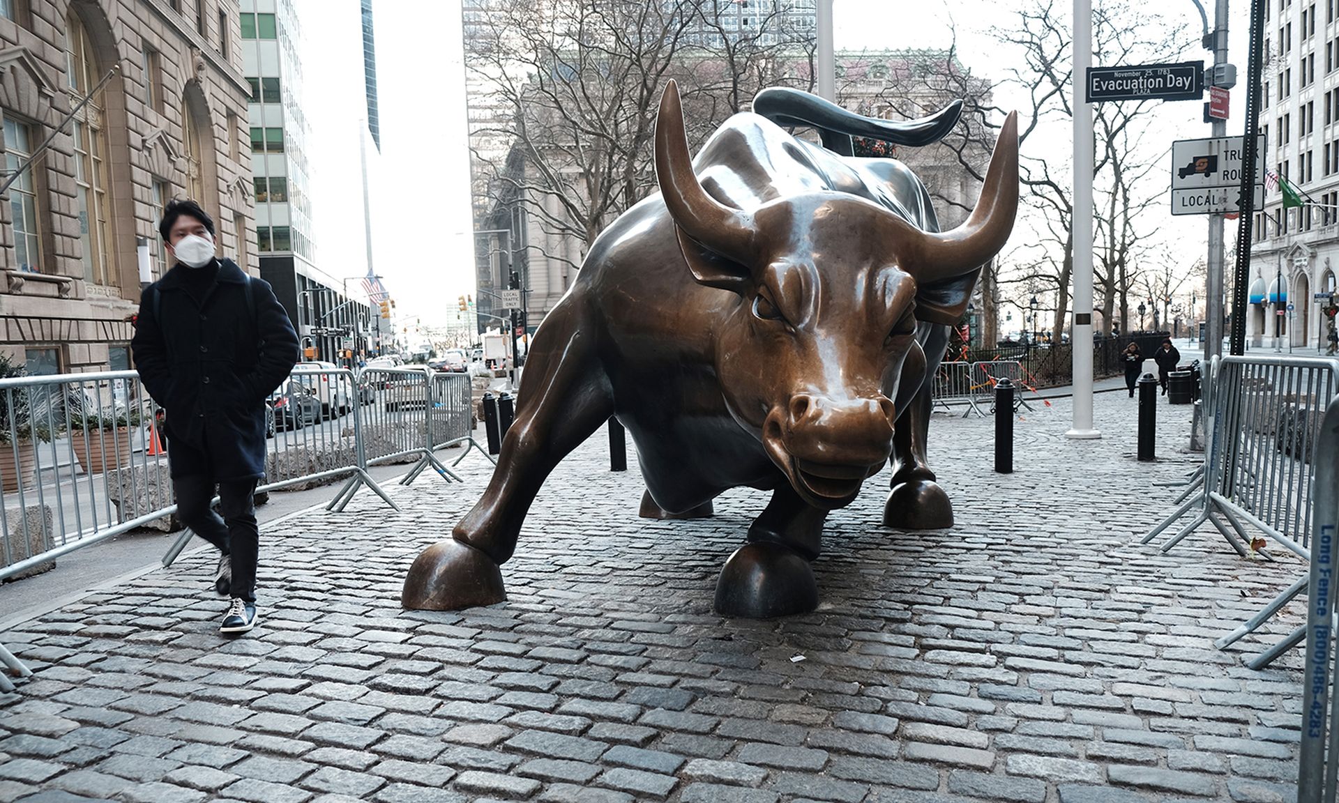 A man walks by the Wall Street Bull by the New York Stock Exchange (NYSE) on Jan. 11, 2022, in New York City. (Photo by Spencer Platt/Getty Images)