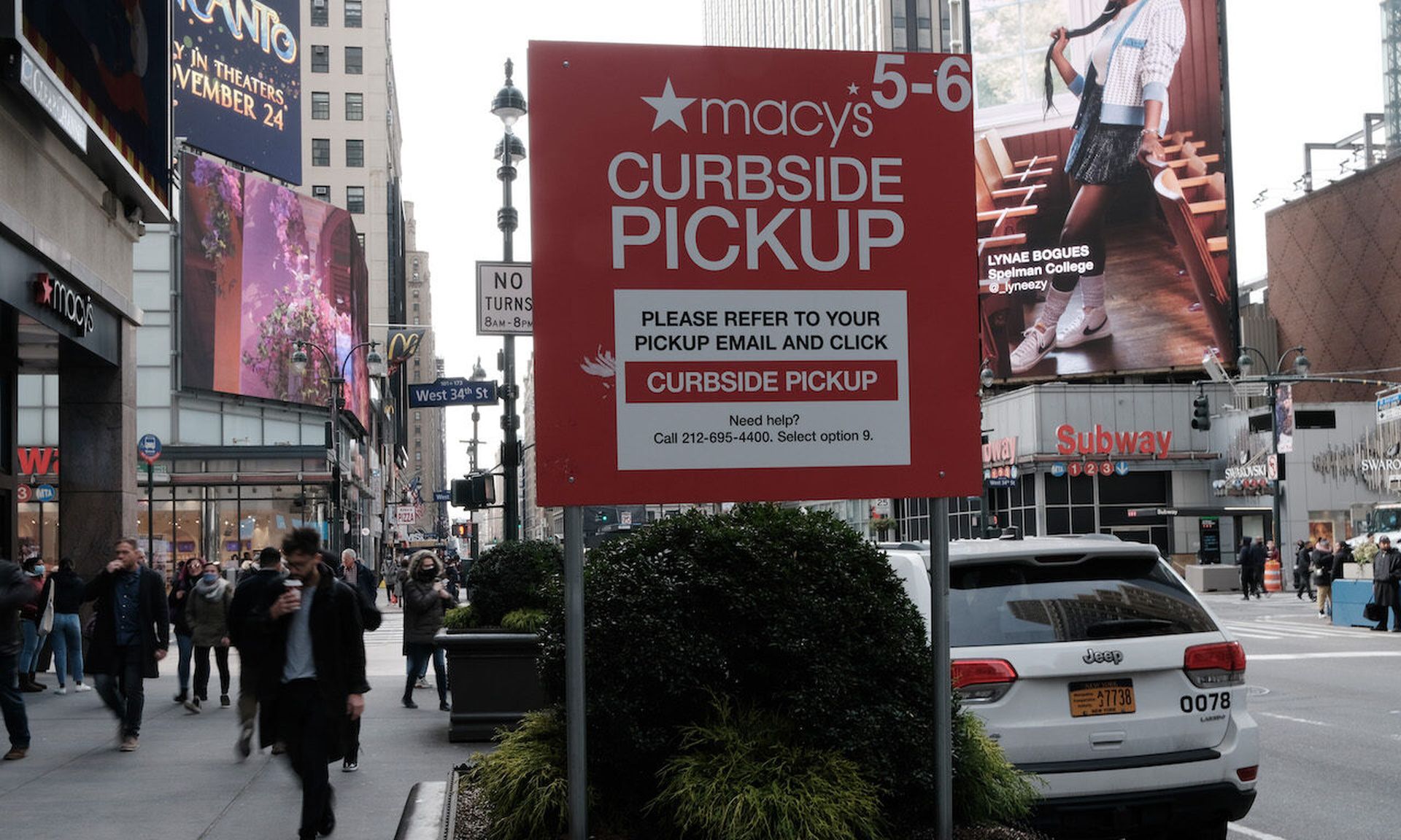 A Macy&#8217;s curbside pickup sign stands out as people walk along a main shopping street in Manhattan on November 17, 2021. Today’s columnist, Yohanna Andom of Forter, points out that as retailing shifted to ecommerce during the pandemic, more brick-and-mortar stores started offering hybrid options where consumers could makes purchases online and...