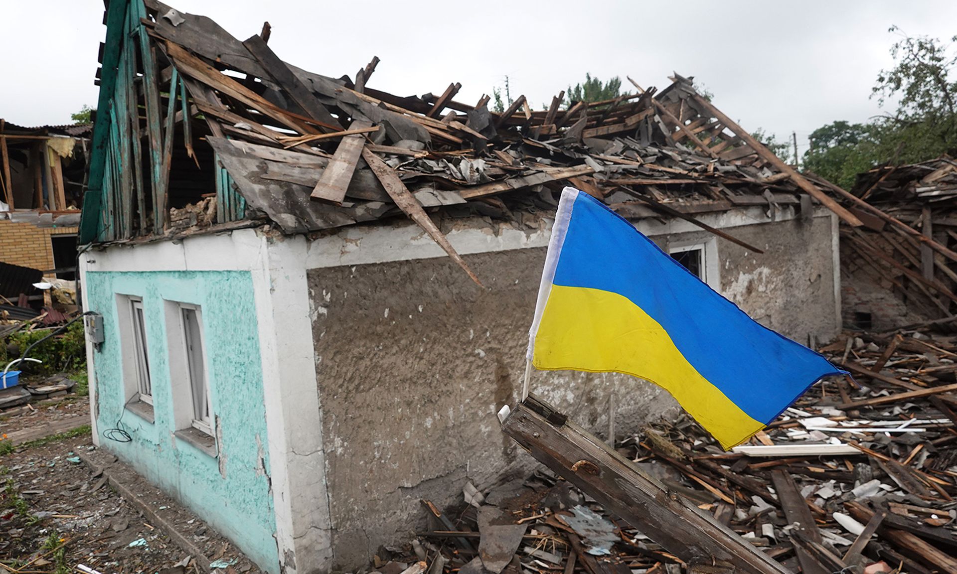 A Ukrainian flag flies next to a home that was heavily damaged by a Russian rocket attack on June 15, 2022, in Dobropillia, Ukraine. (Photo by Scott Olson/Getty Images)