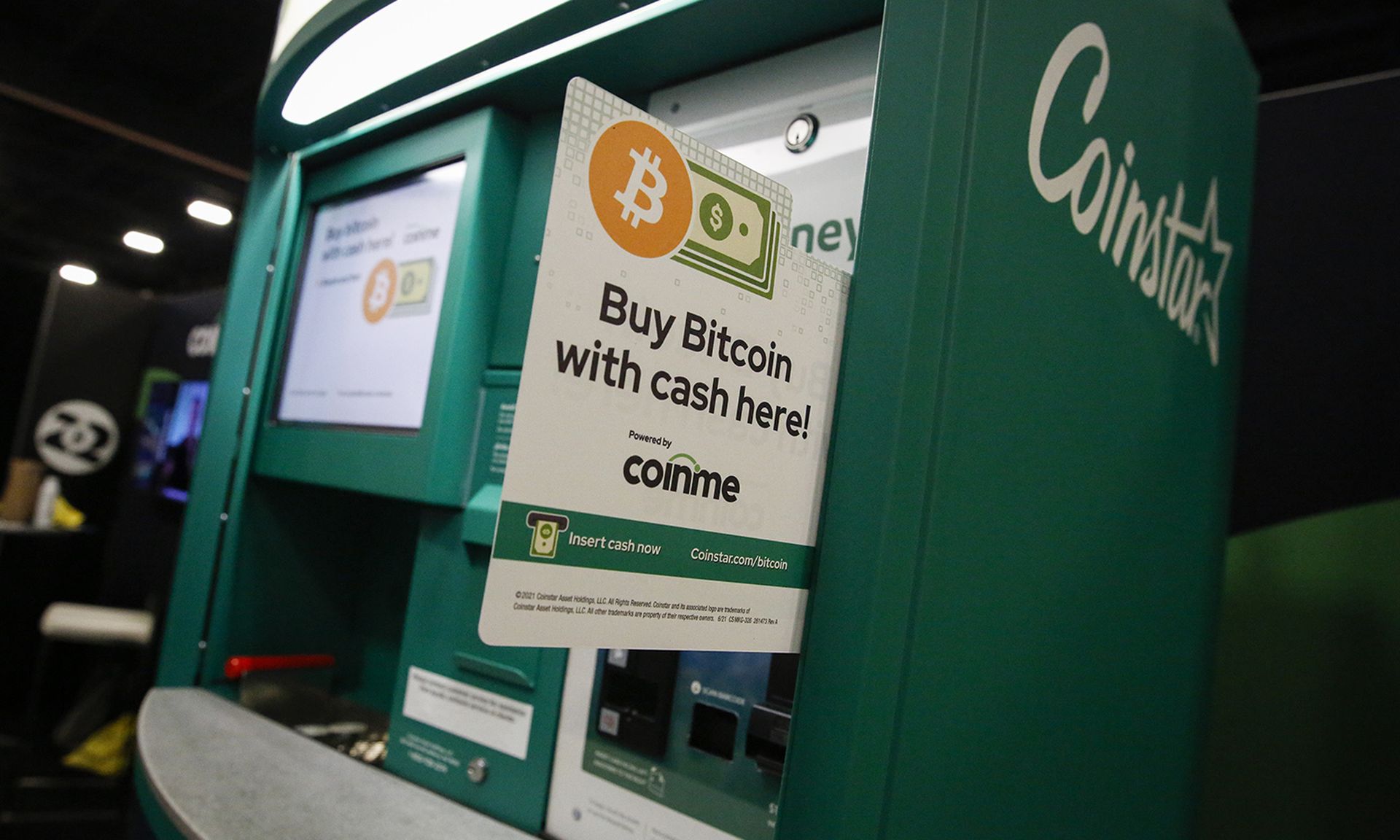 A sign that says "buy bitcoin" is seen in a Coinstar ATM