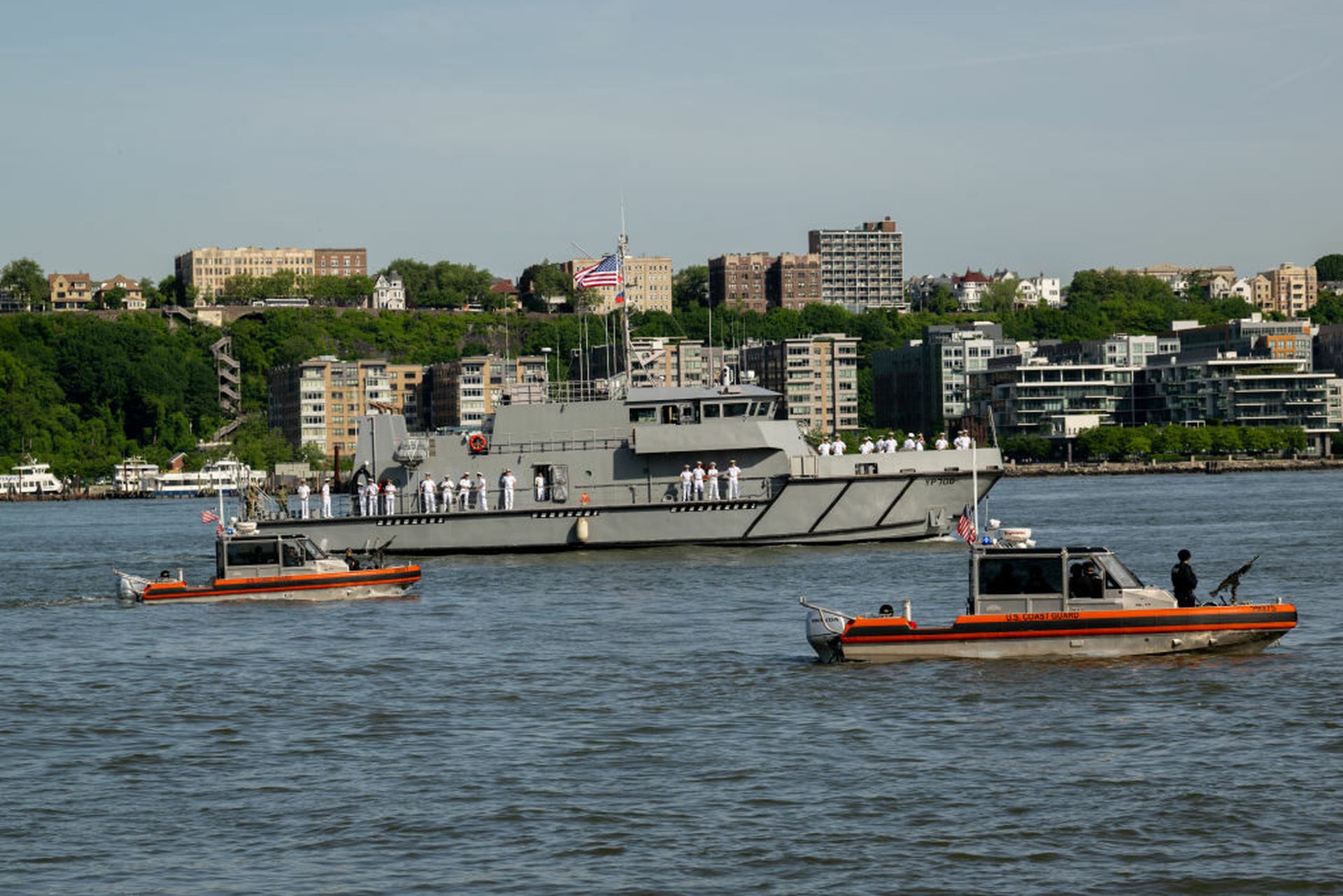 U.S. Coast Guard vessels patrol as a Navy ship arrives for Fleet Week in New York City.