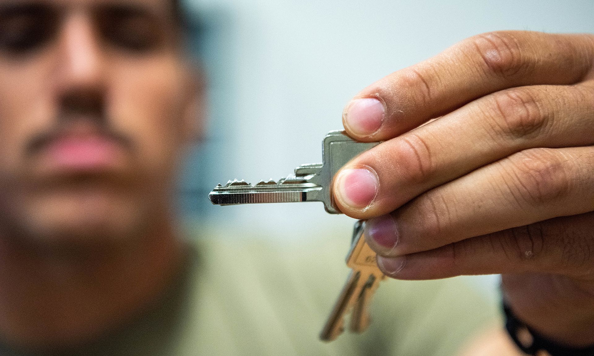 A locksmith inspects a key.