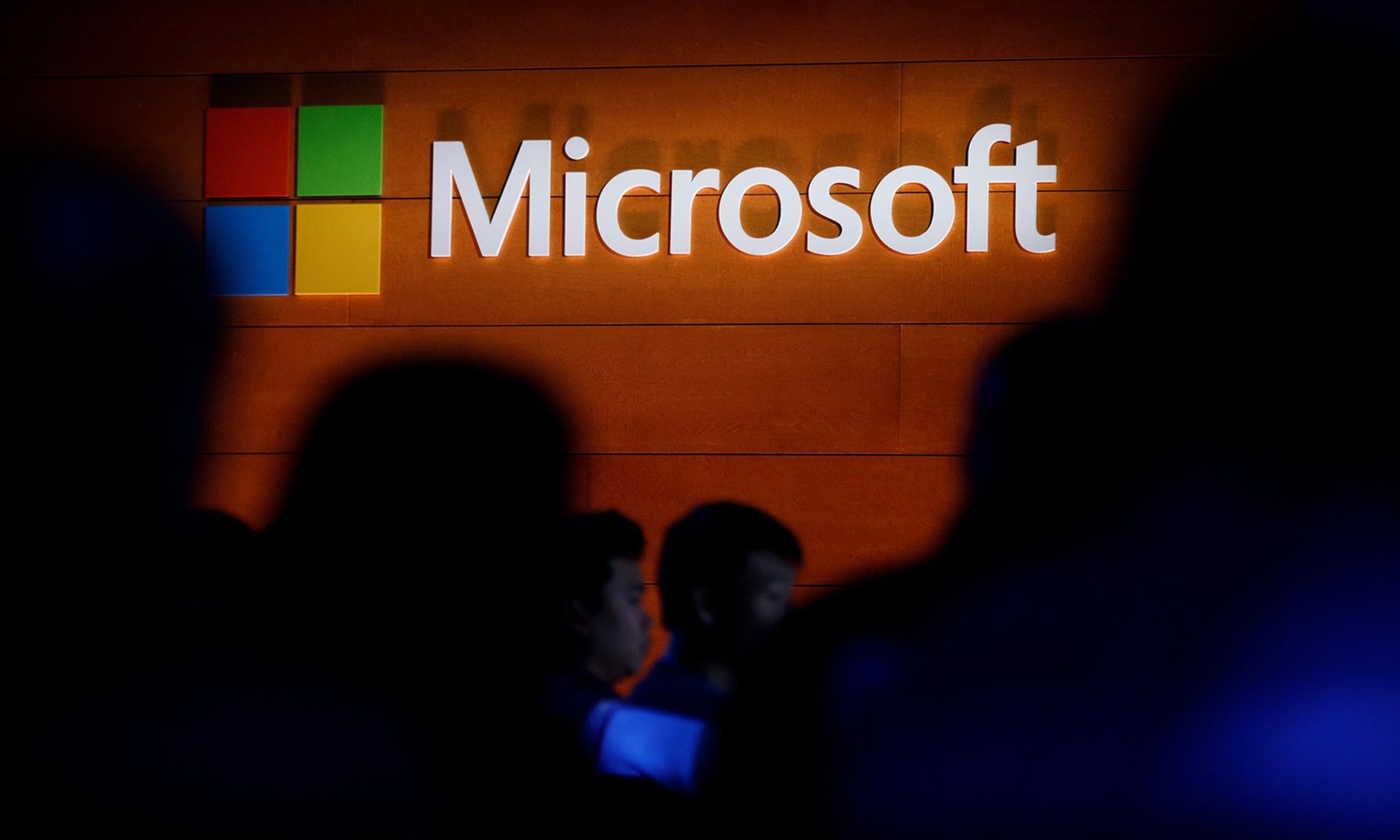 The Microsoft logo is illuminated on a wall