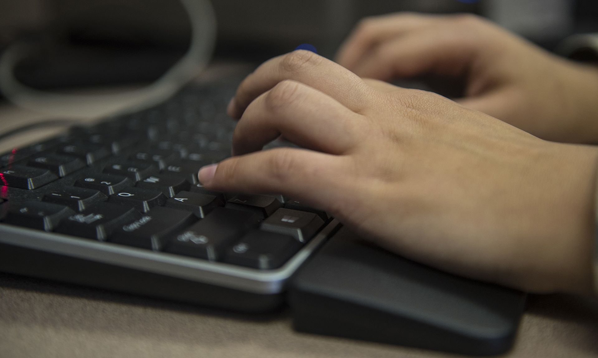 A customer service technician types on a computer.