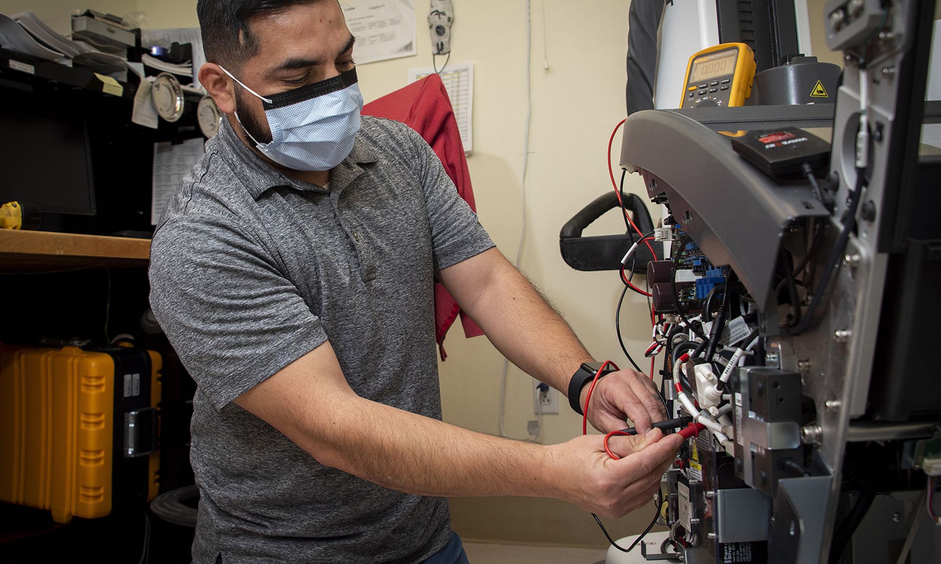 A biomedical engineering technician tests power on a portable X-ray unit.