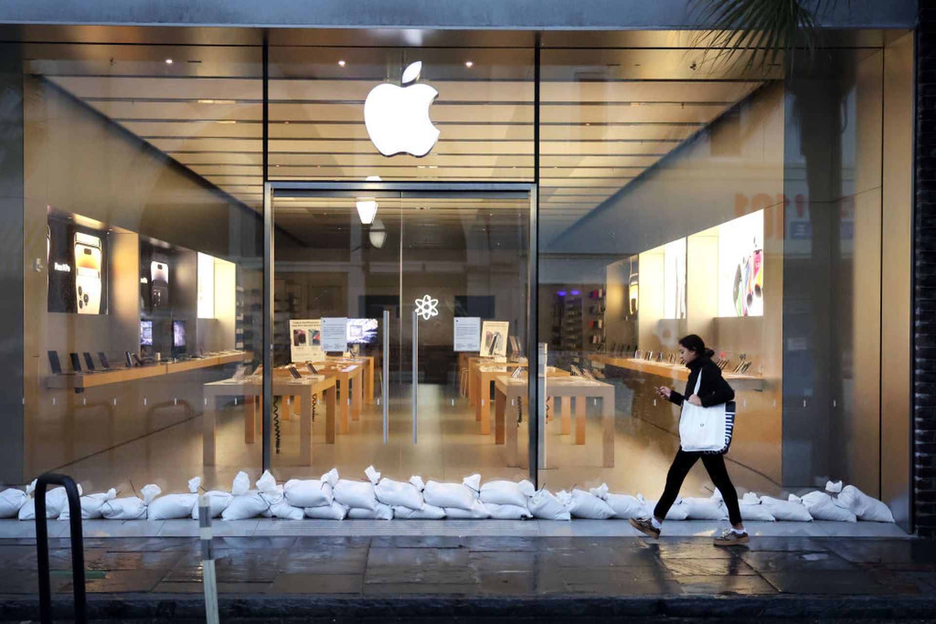 A woman walks past a shuttered Apple store in Charleston, South Carolina. Researchers found a flaw in Safari that could go around Mac endpoint security by leveraging a crafted ZIP archive vulnerability. (Photo by Scott Olson/Getty Images)