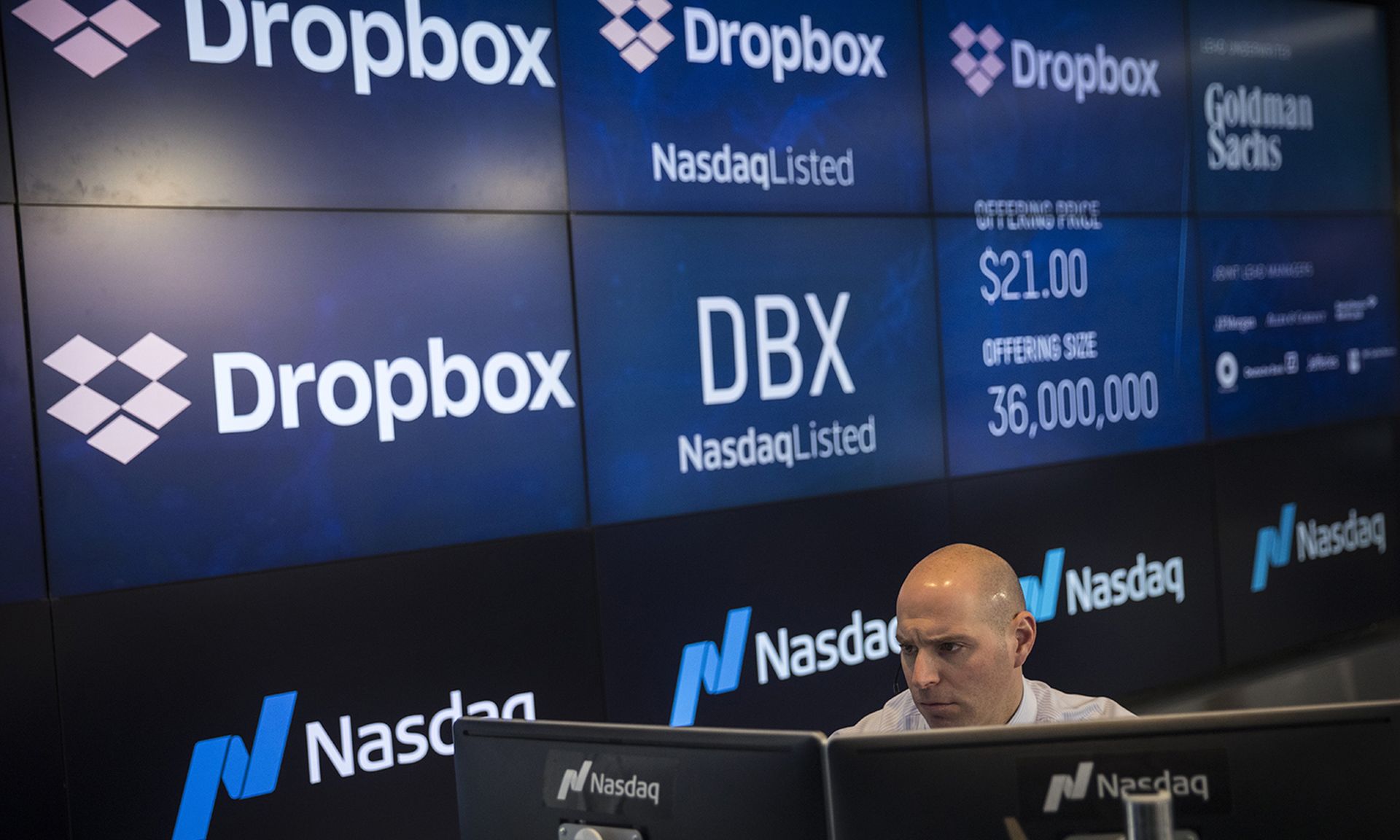 A Nasdaq official in New York City monitors a computer screen as trading starts on cloud storage provider DropBox in 2018. (Photo by Drew Angerer/Getty Images)