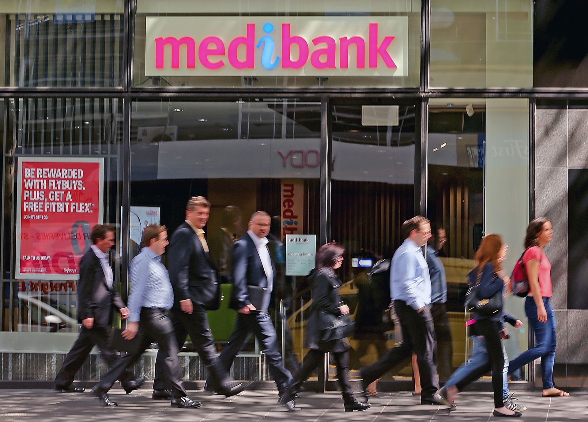 People walk past a Medibank branch.