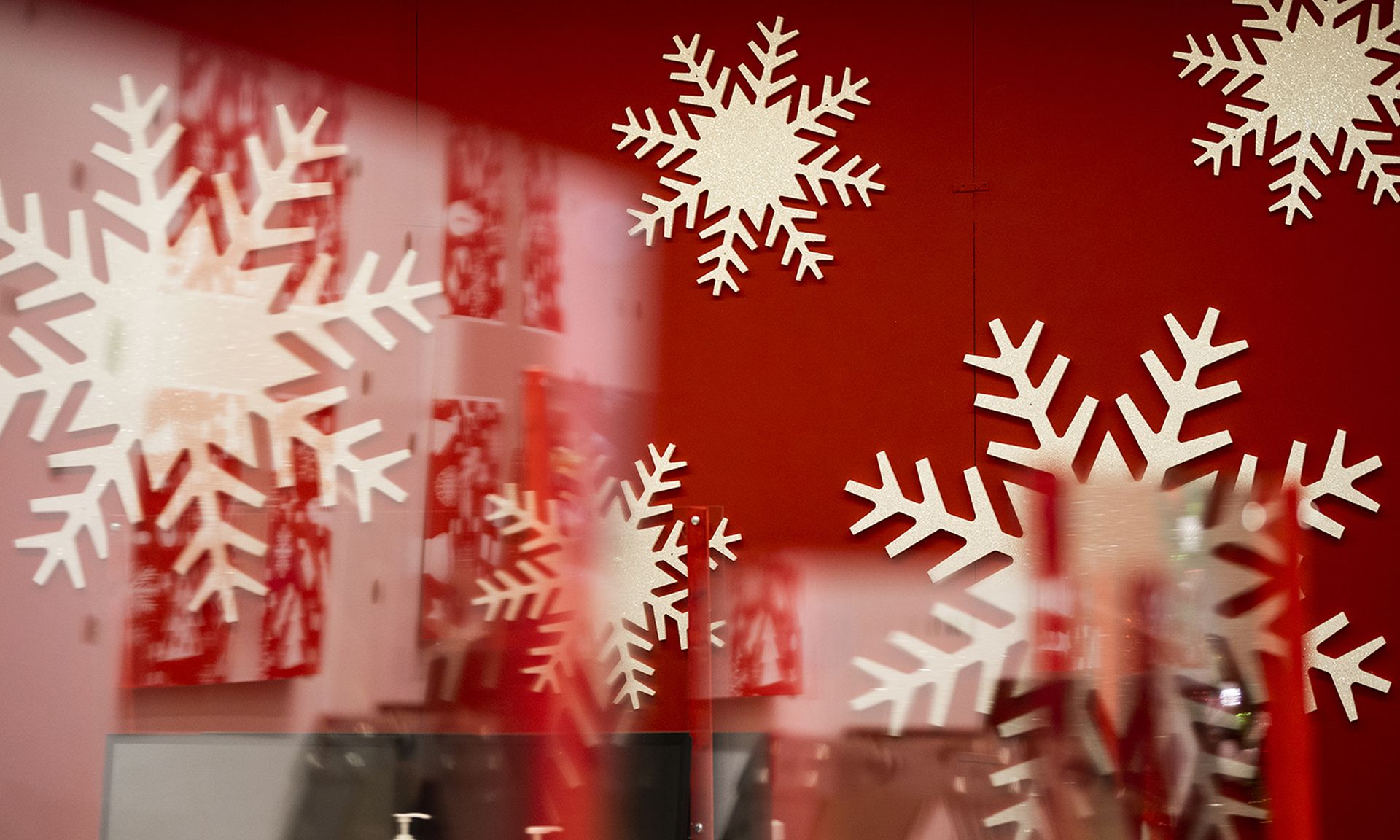 Snowflake decorations are seen through plexiglass.