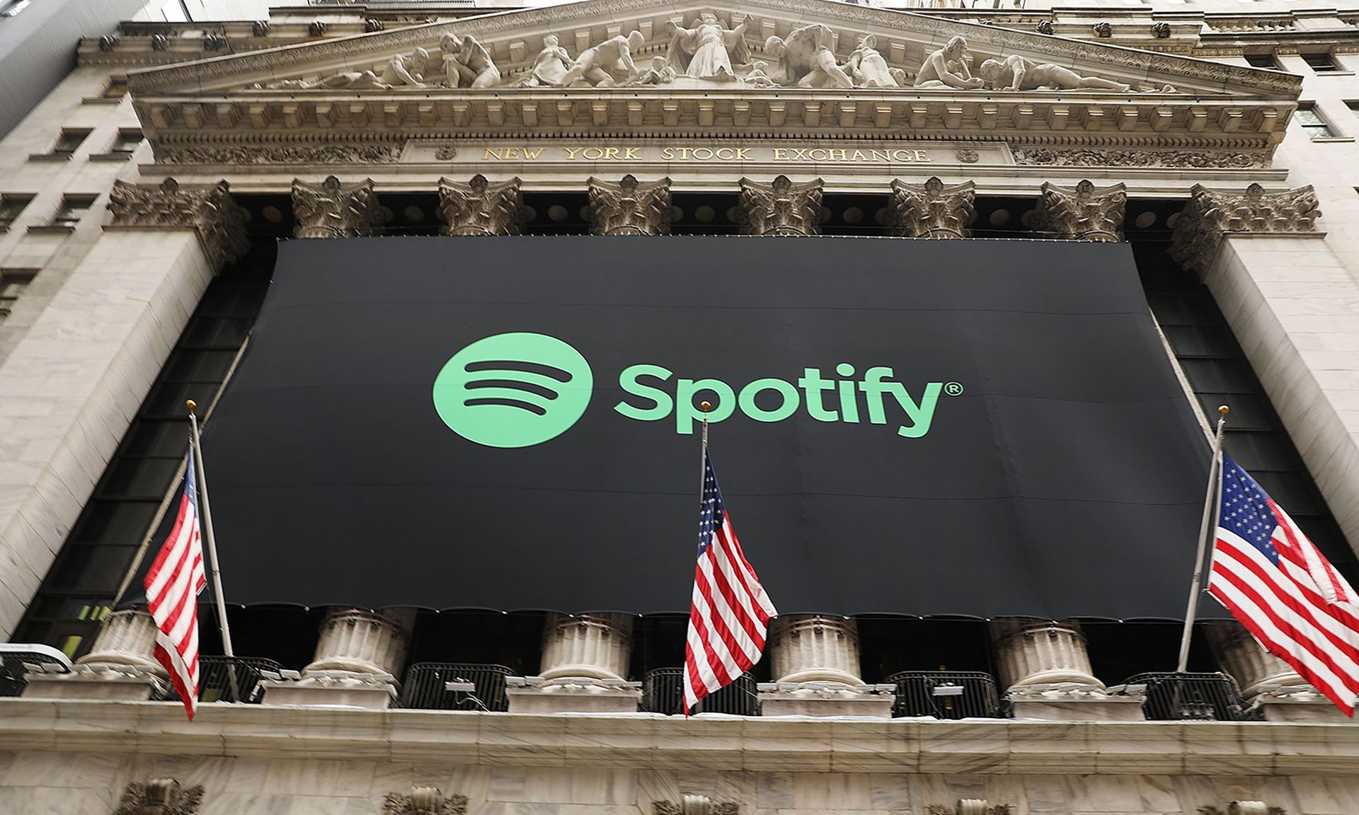 The Spotify logo is displayed on the outside of the New York Stock Exchange building.