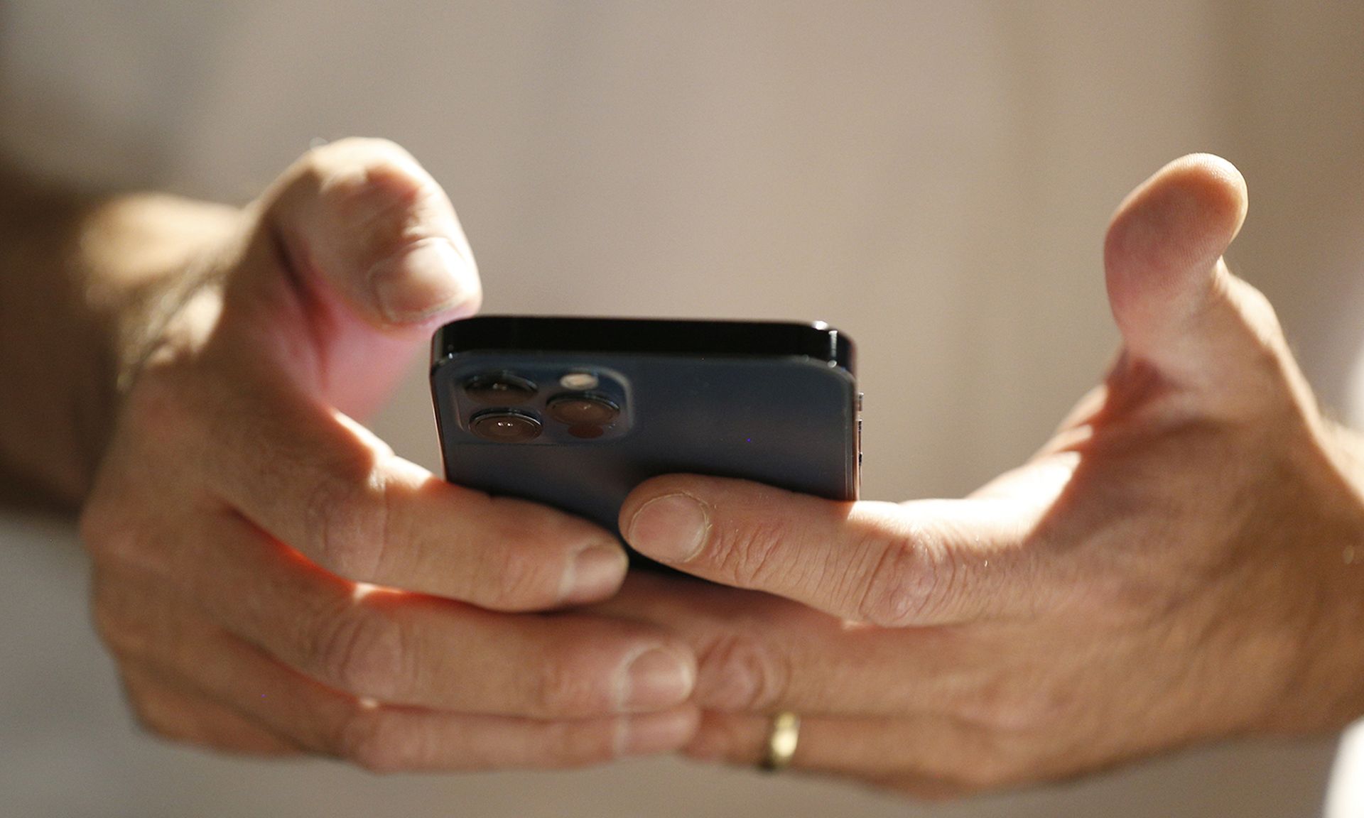 A man's hands hold a smartphone