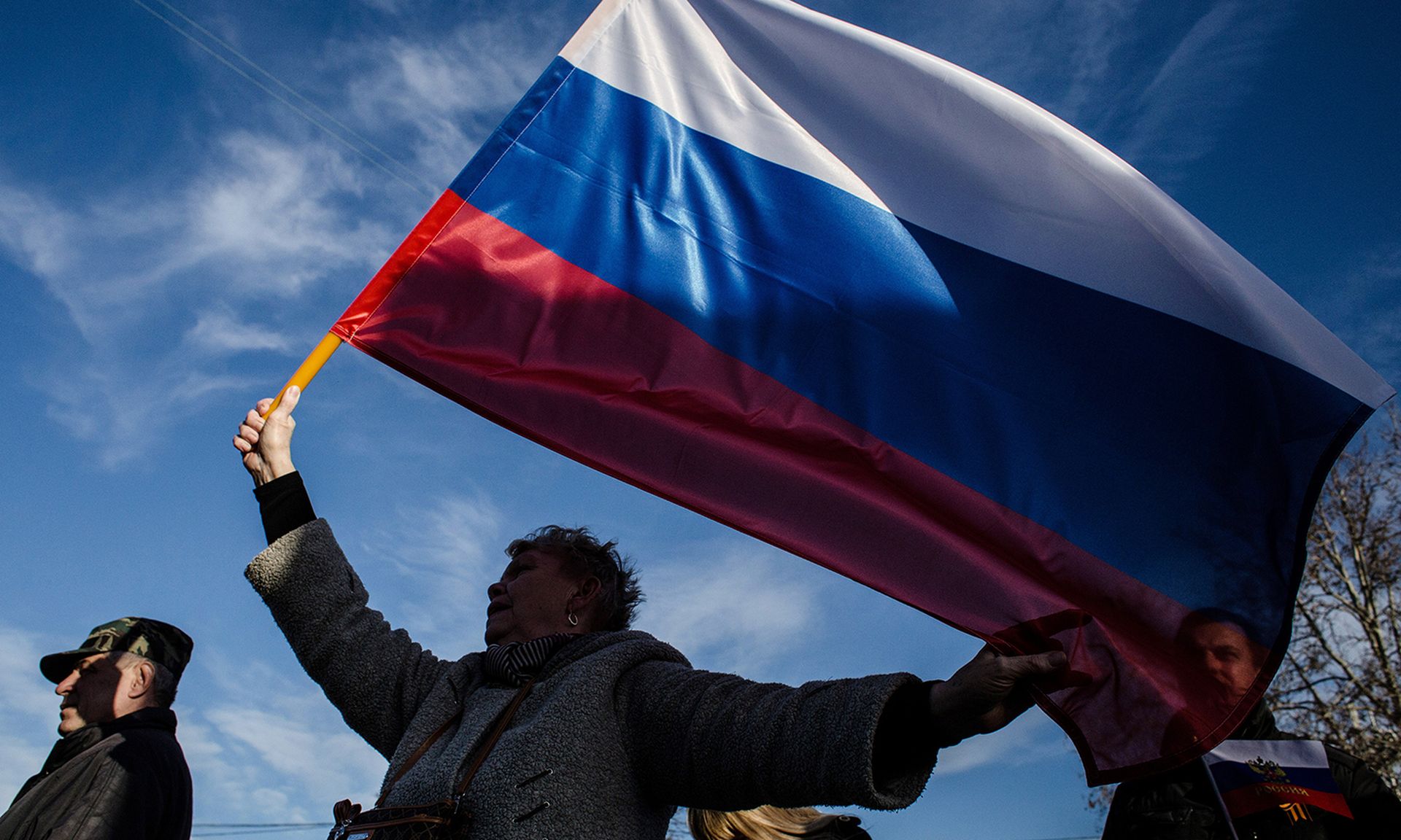 A woman waves a Russian flag