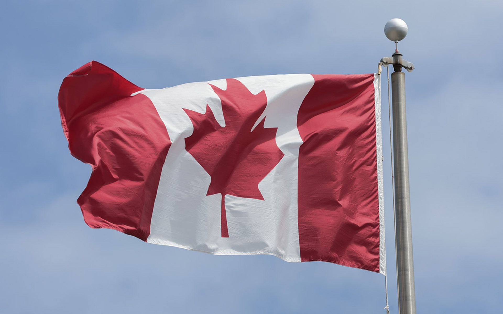 The Canadian flag flies on a flagpole