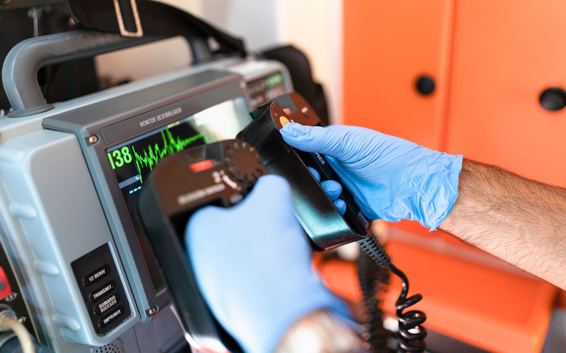 a doctor's hands hold the defibrillator paddles.