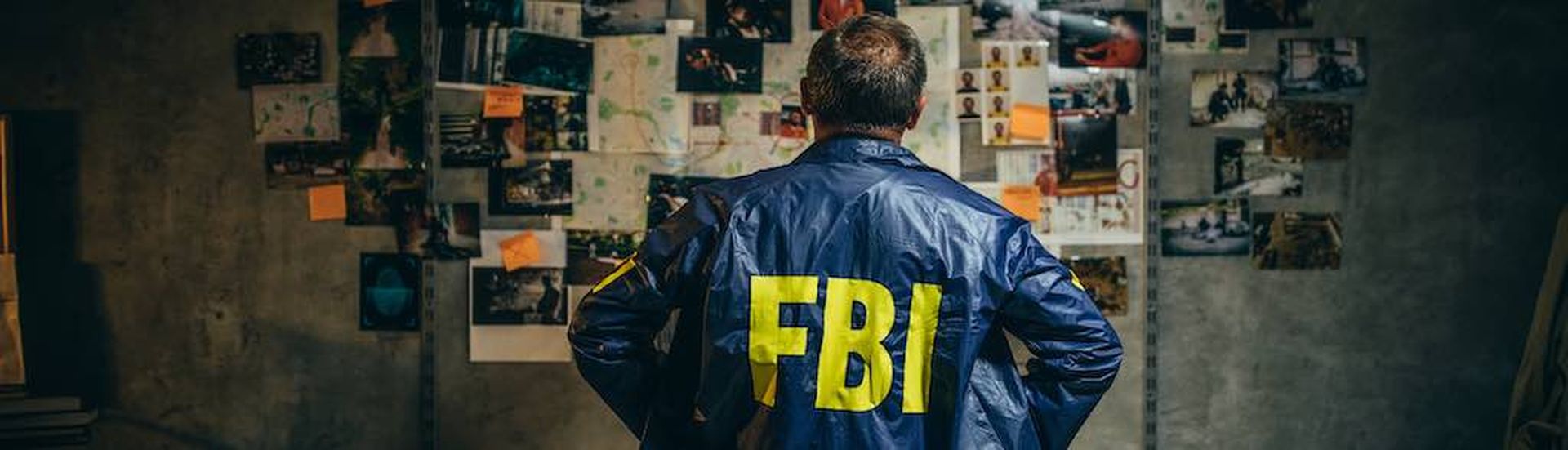 One man, mature FBI agent working on a case in dark office.