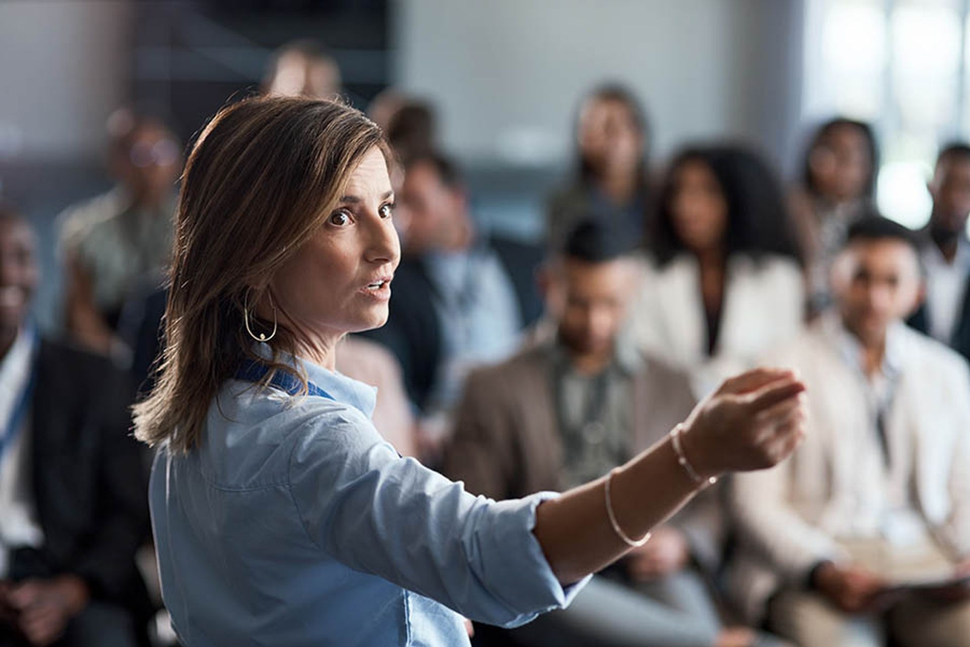 Presentation, training and coaching with a business woman talking to an audience during a workshop. Convention, speech and teaching with a female speaker giving a seminar to a group of employees.