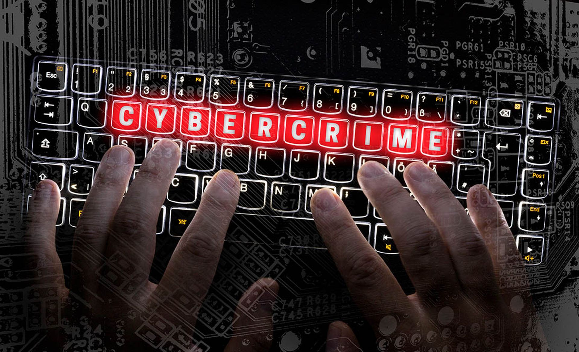 The word "cybercrime" is illuminated in a red on a computer keyboard
