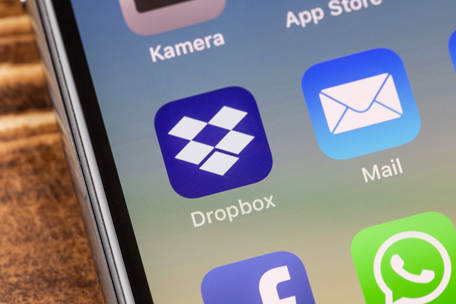 Close up to dropbox app on the screen of an iPhone X with personalized background