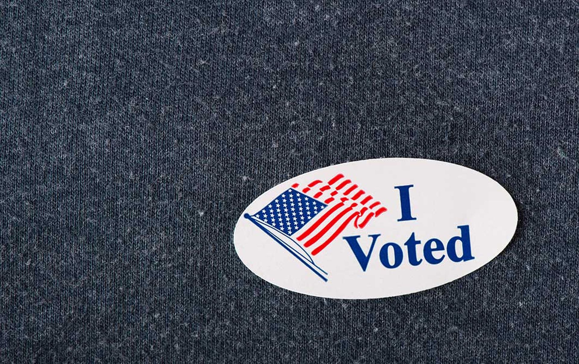 Closeup of an American "I voted" sticker placed on a navy shirt.