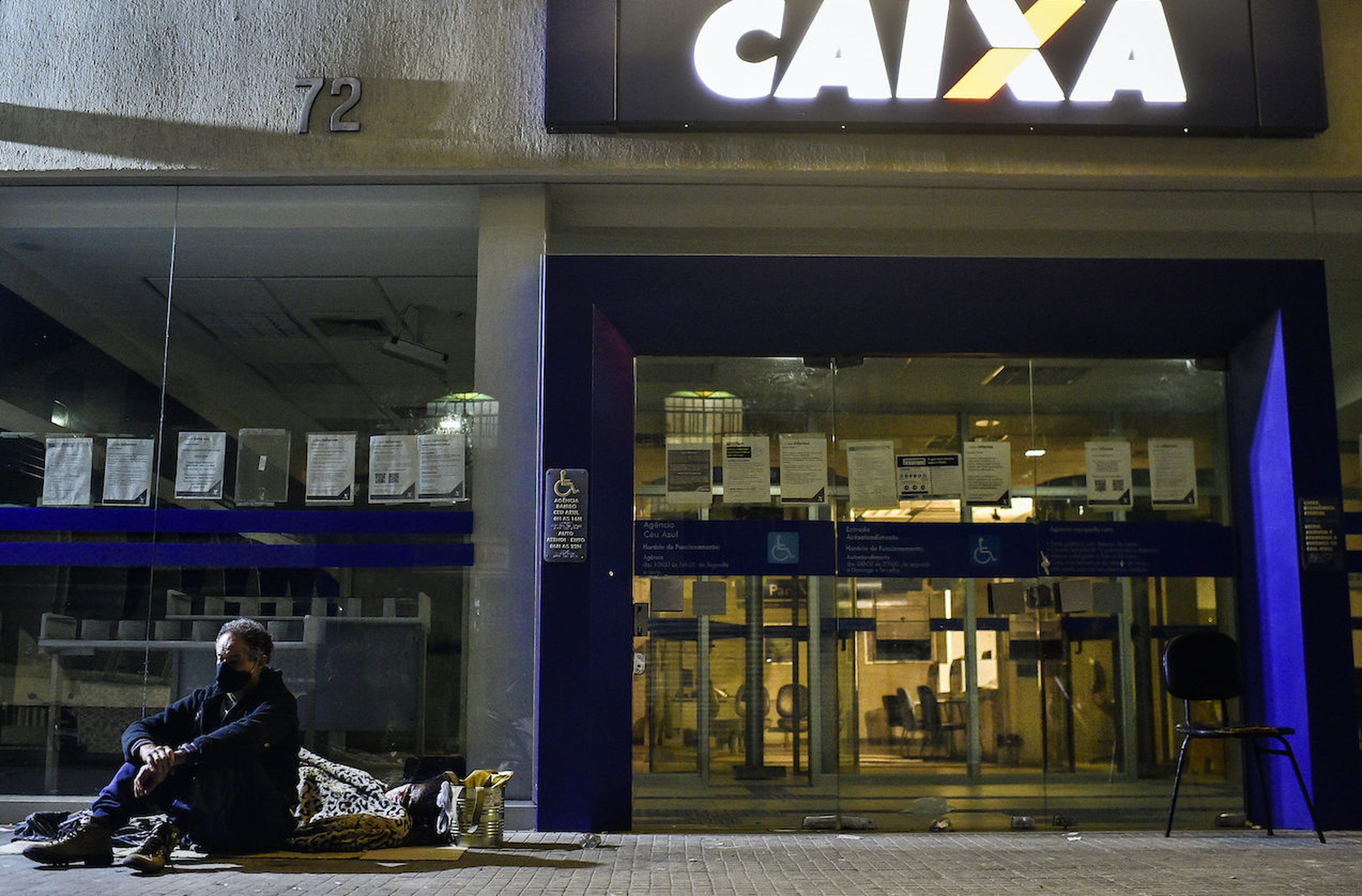 People sleep waiting in line outside a Caixa Economica Federal bank to receive urgent government benefit amidst the COVID-19 struggles in Belo Horizonte, Brazil. Beyond the pandemic, banks combat the Brazil-based Guildma cybercriminal gang that developed a new Android-based trojan that has now gone global. (Pedro Vilela/Getty Images)