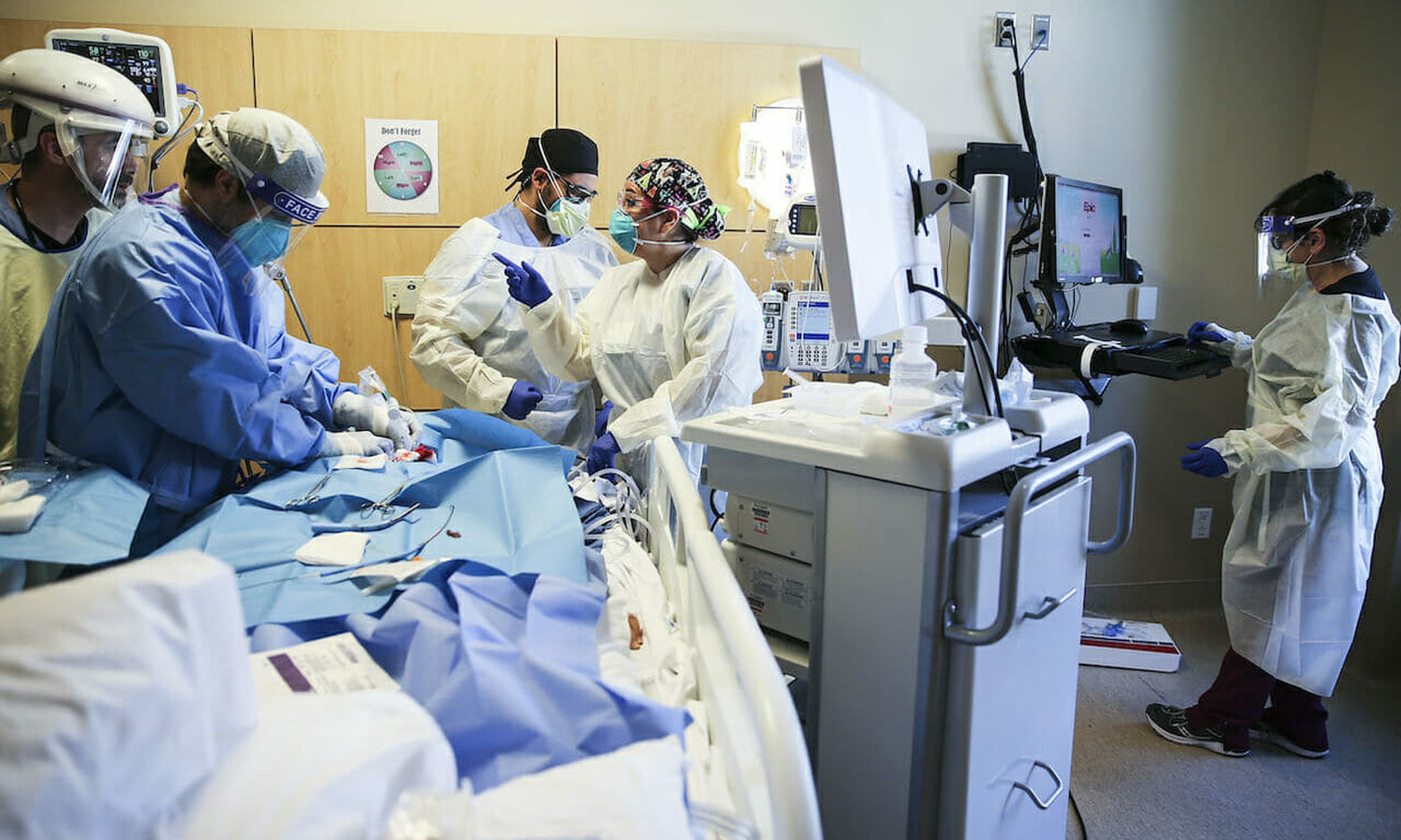 Clinicians perform a tracheostomy on a patient in a COVID-19 ICU Intensive Care Unit in Los Angeles. In the wake of the SolarWinds incident, an increasing number of health care institutions are embarking on threat-hunting missions to seek and destroy exploitable vulnerabilities. (Photo by Mario Tama/Getty Images)