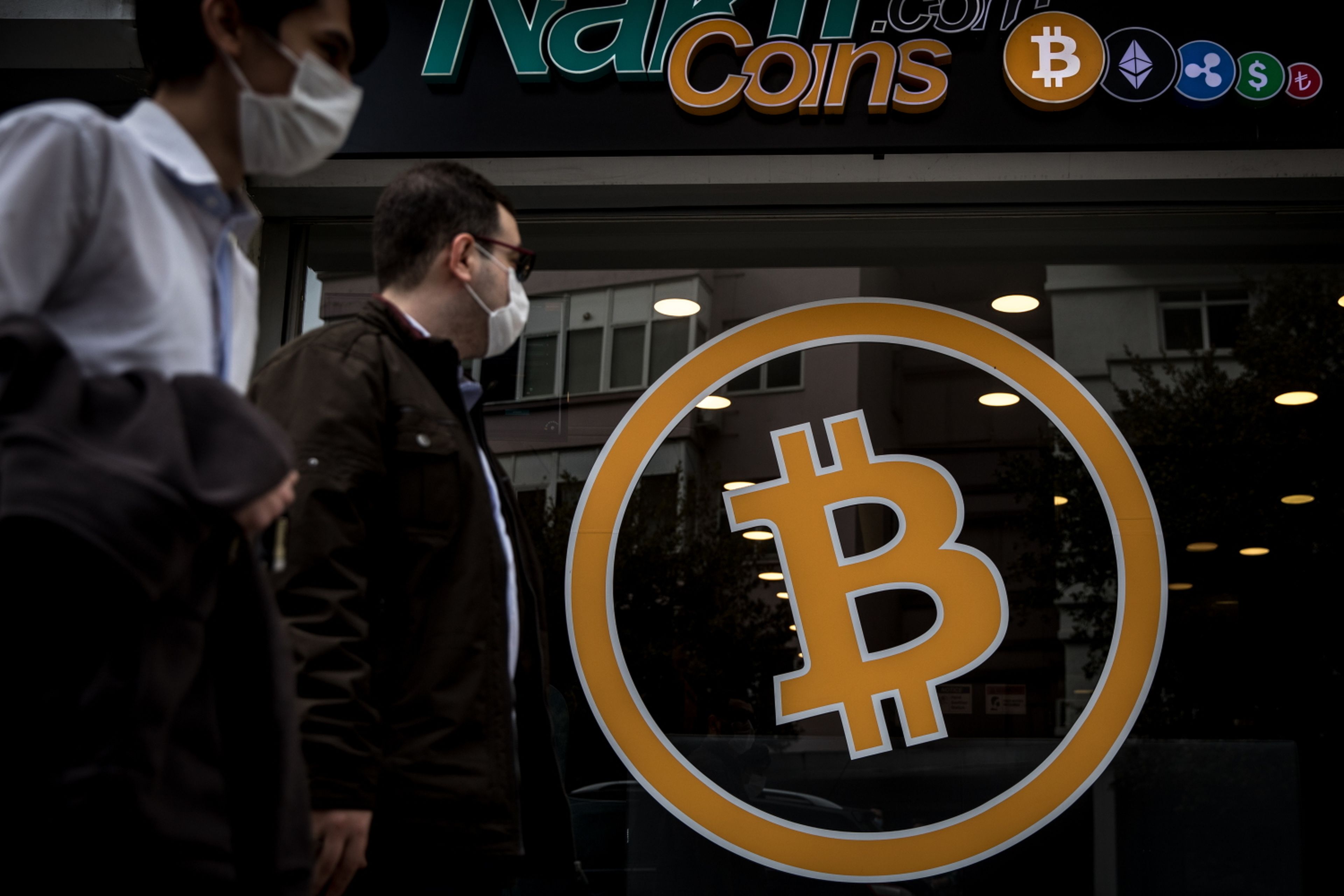 People walk past the entrance of a cryptocurrency exchange office on April 16, 2021, in Istanbul, Turkey. The European Commission is proposing to expand money-laundering rules to cryptocurrency. (Chris McGrath/Getty Images)