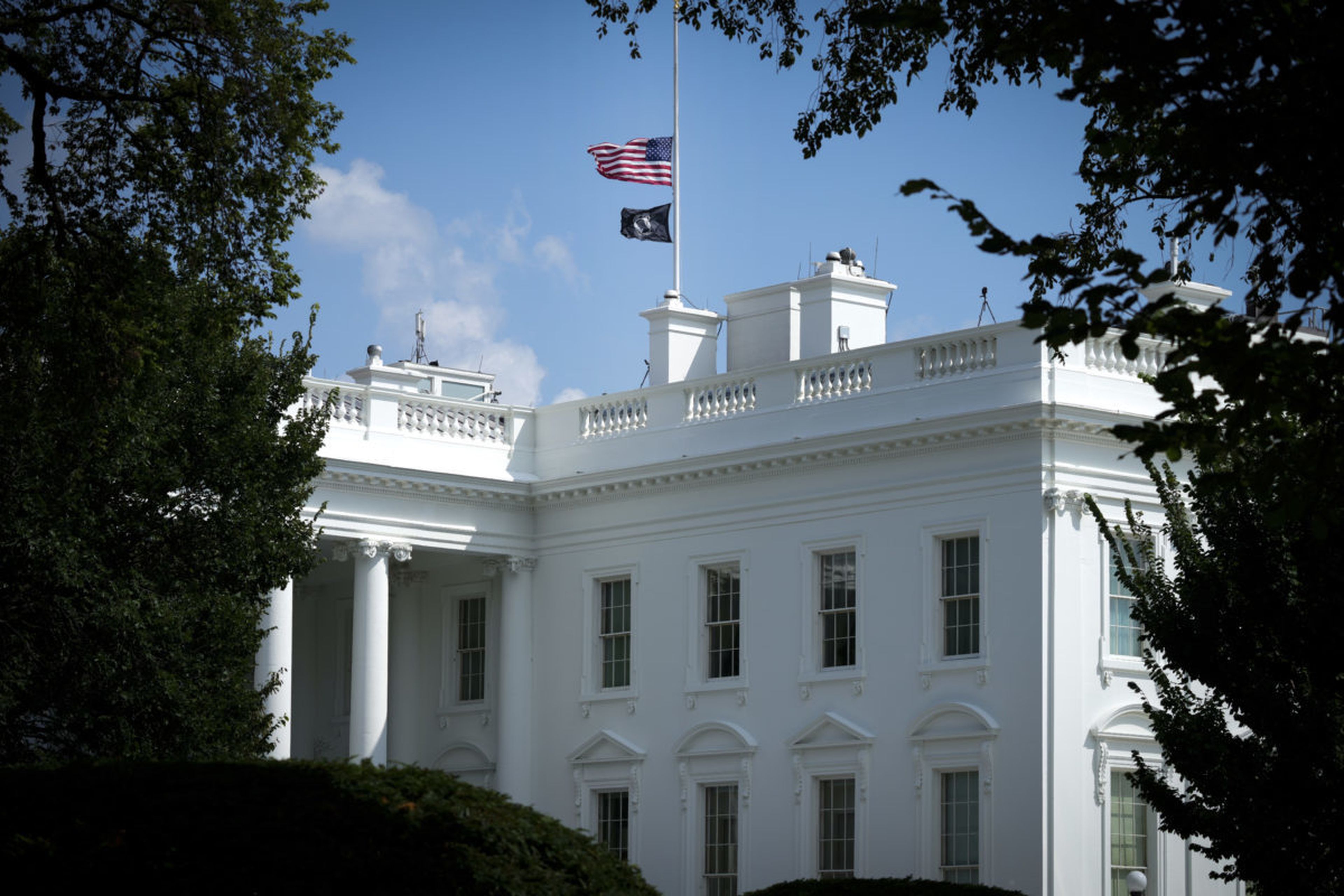 WASHINGTON, DC &#8211; AUGUST 27: The American flag and National League of Families POW/MIA Flag on top of the White House stand at half staff to honor the U.S. service members killed in terror attacks in Kabul Afghanistan, on August 27, 2021 in Washington, DC. The White House&#8217;s administrative arm released a memo on how agencies should be log...