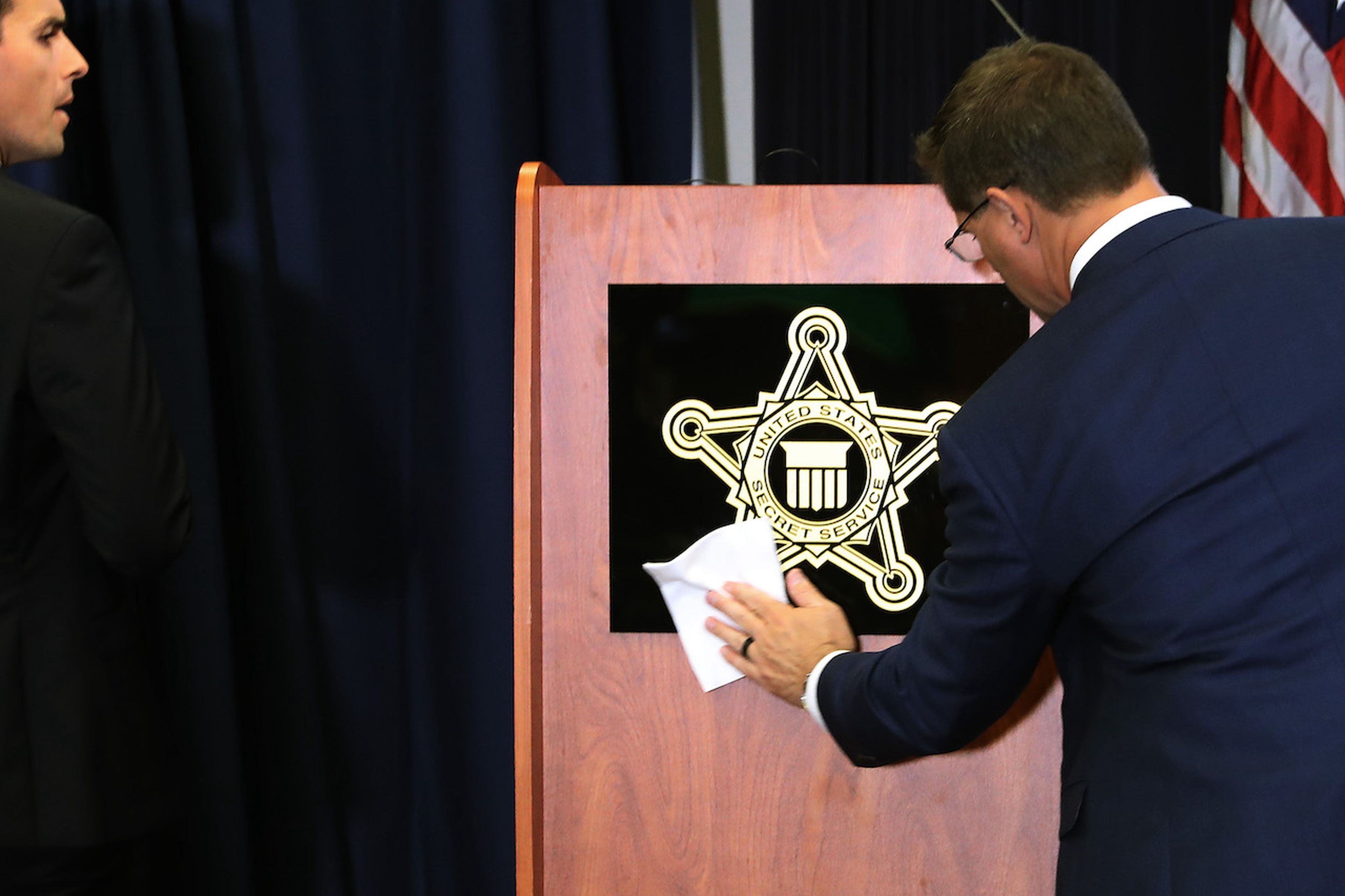 A sign with the U.S. Secret Service shield is cleaned before a briefing in 2019 in Washington, D.C. The Secret Service and U.S. Postal Service opened an investigation into a wide-ranging scheme to defraud businesses in August. (Photo by Chip Somodevilla/Getty Images)