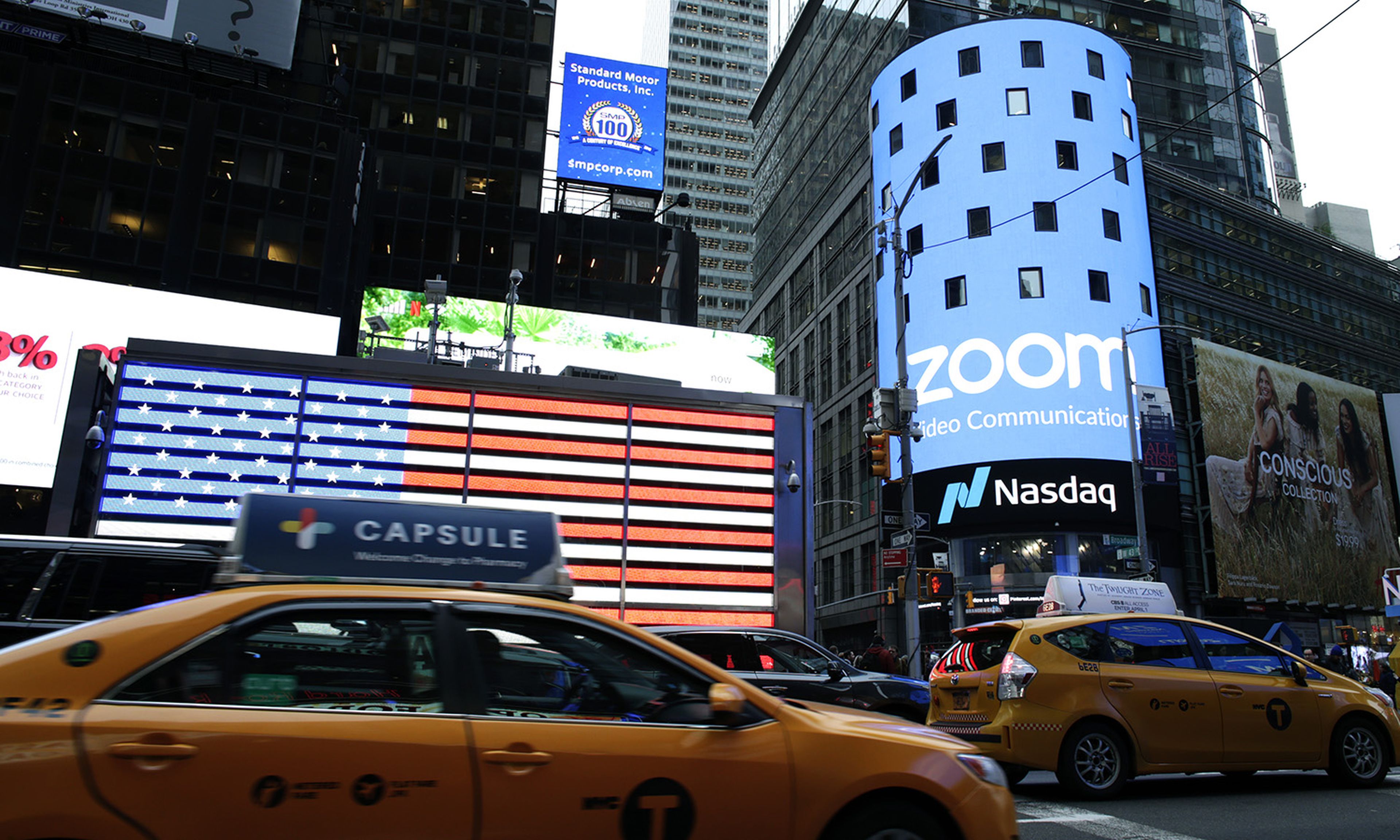 People pass by the Nasdaq building as the screen shows the logo of the video-conferencing software company Zoom on April 18, 2019, in New York City. (Photo by Kena Betancur/Getty Images)