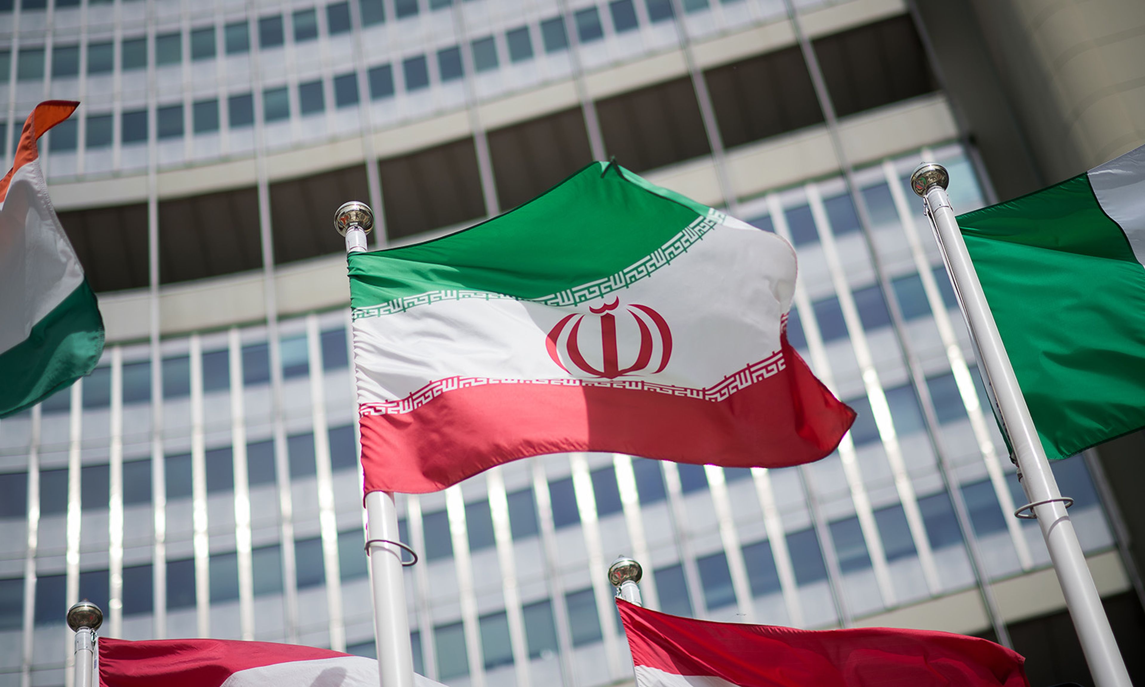The Iranian flag is seen in front of the building of the International Atomic Energy Agency (IAEA) Headquarters on May 24, 2021, in Vienna, Austria. (Photo by Michael Gruber/Getty Images)