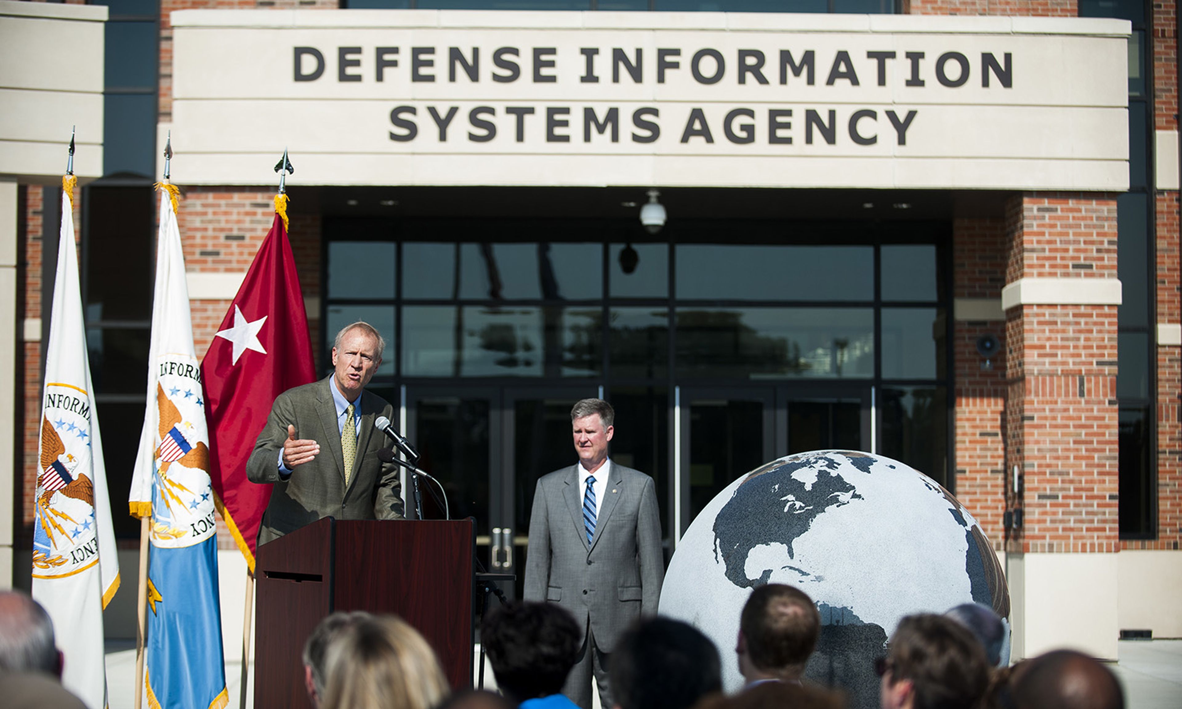 The Defense Information Systems Agency and Booz Allen Hamilton are partnering on a $6.8 million pilot to develop a new security model based on zero trust principles. Pictured: Then-Illinois Gov. Bruce Rauner delivers a speech during a ribbon-cutting ceremony for DISA&#8217;s new compound at Scott Air Force Base, Ill., Aug. 11, 2016. (Staff Sgt. Cla...