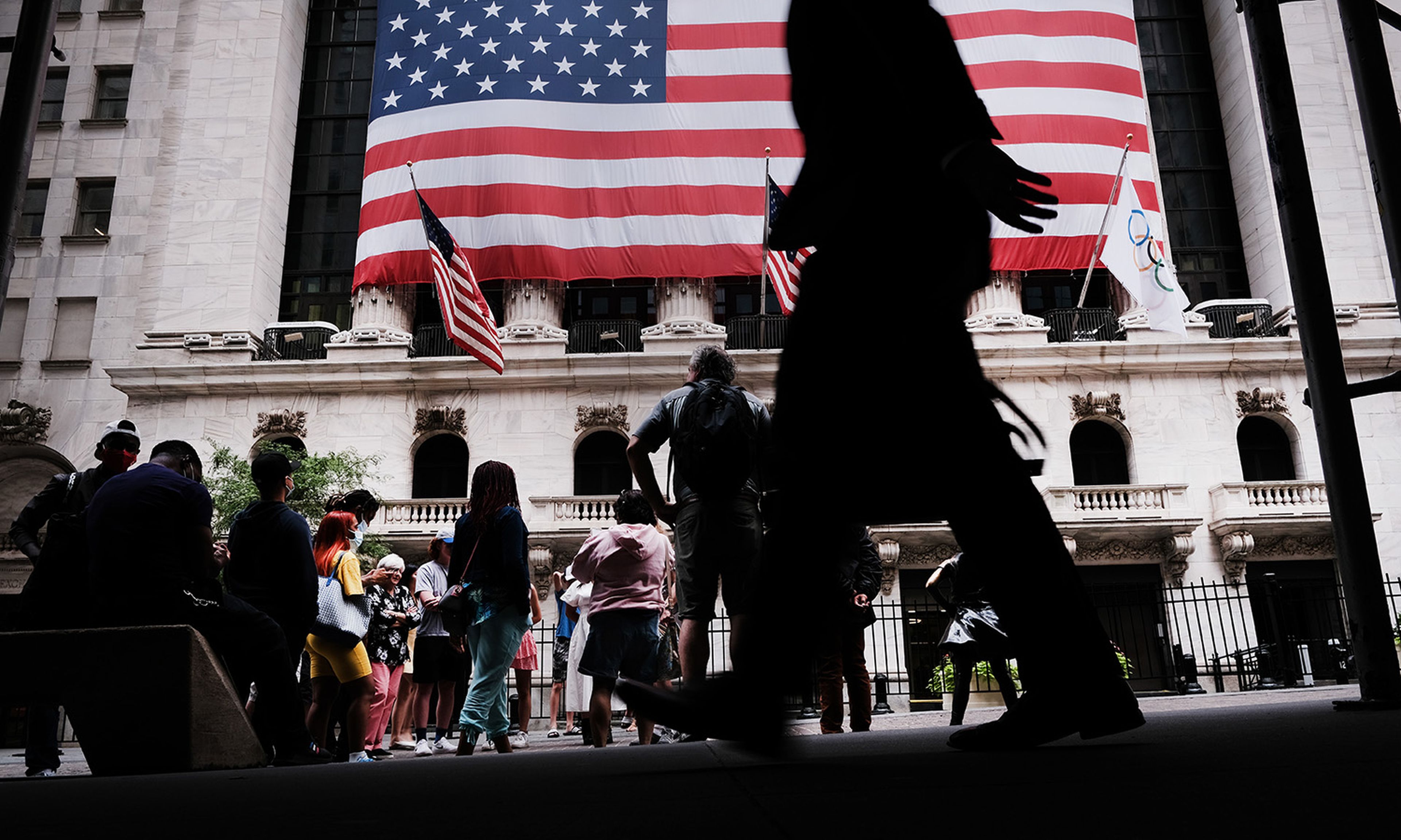 People walk by the New York Stock Exchange on Aug. 10, 2021, in New York City. (Photo by Spencer Platt/Getty Images)