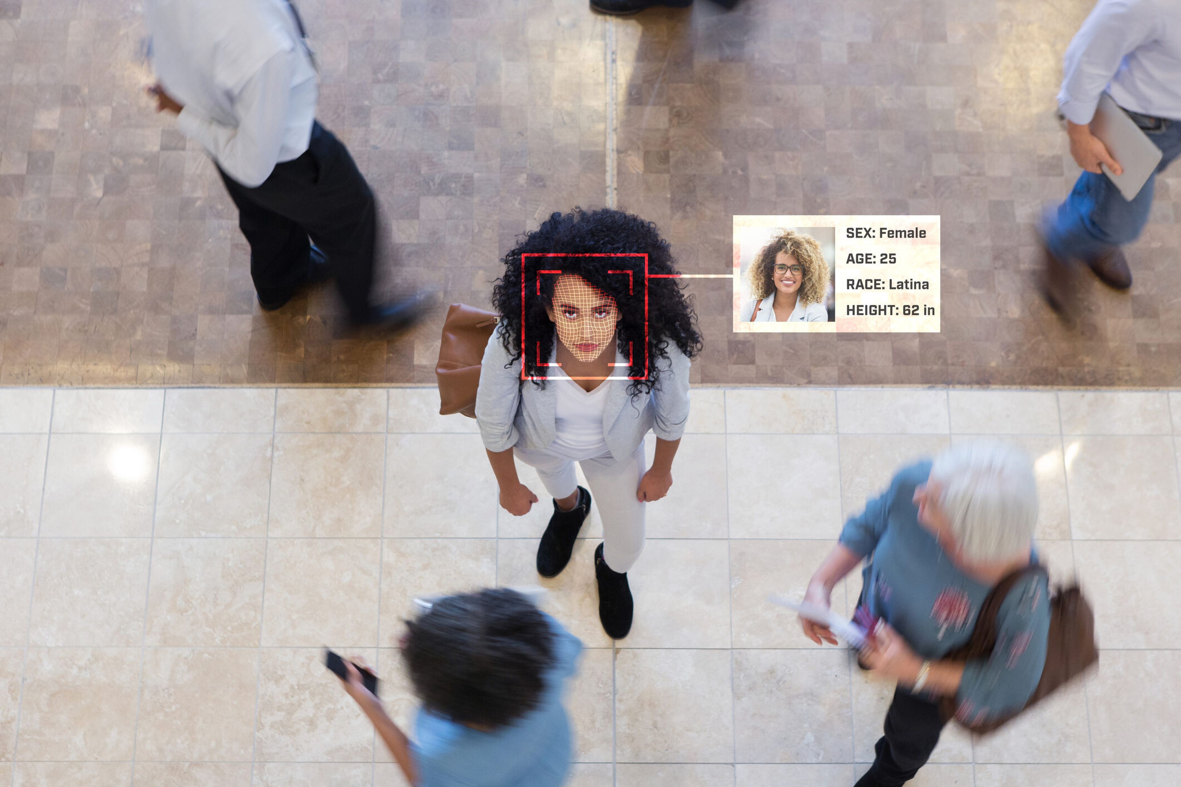 The GSA wants to determine if commercial facial recognition technologies can be incorporated into Login.gov. Pictured: A young Hispanic businesswoman looks up while in an office lobby with businesspeople all around her. (Image credit: SDI Productions via Getty)