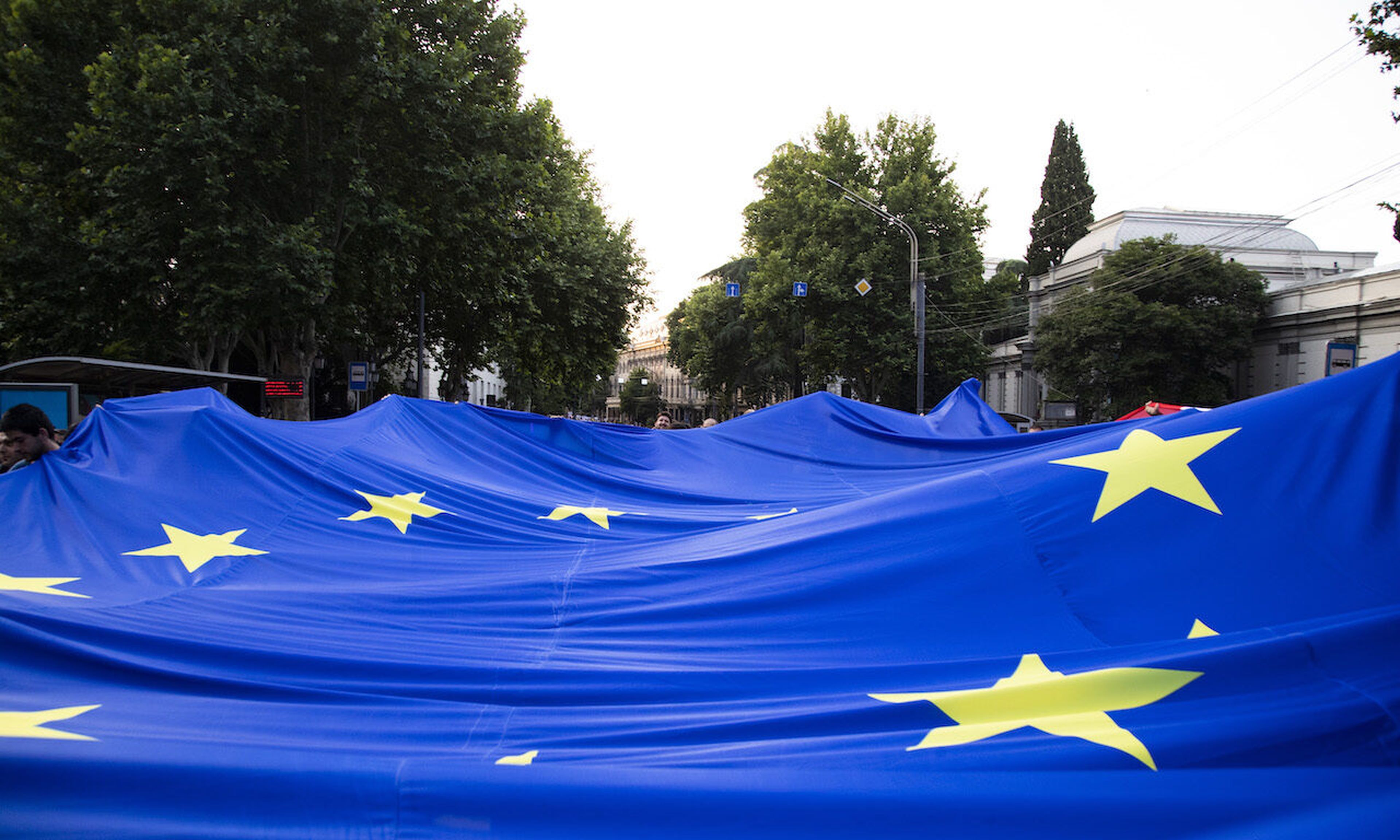 Demonstrators carry a large European Union flag as they march on June 20, 2022, in Tbilisi, Georgia. Today’s columnist, Ross Hosman of Drata, says that a focus on compliance can save companies hefty GDPR and CCPA fines. Photo by Daro Sulakauri/Getty Images)
