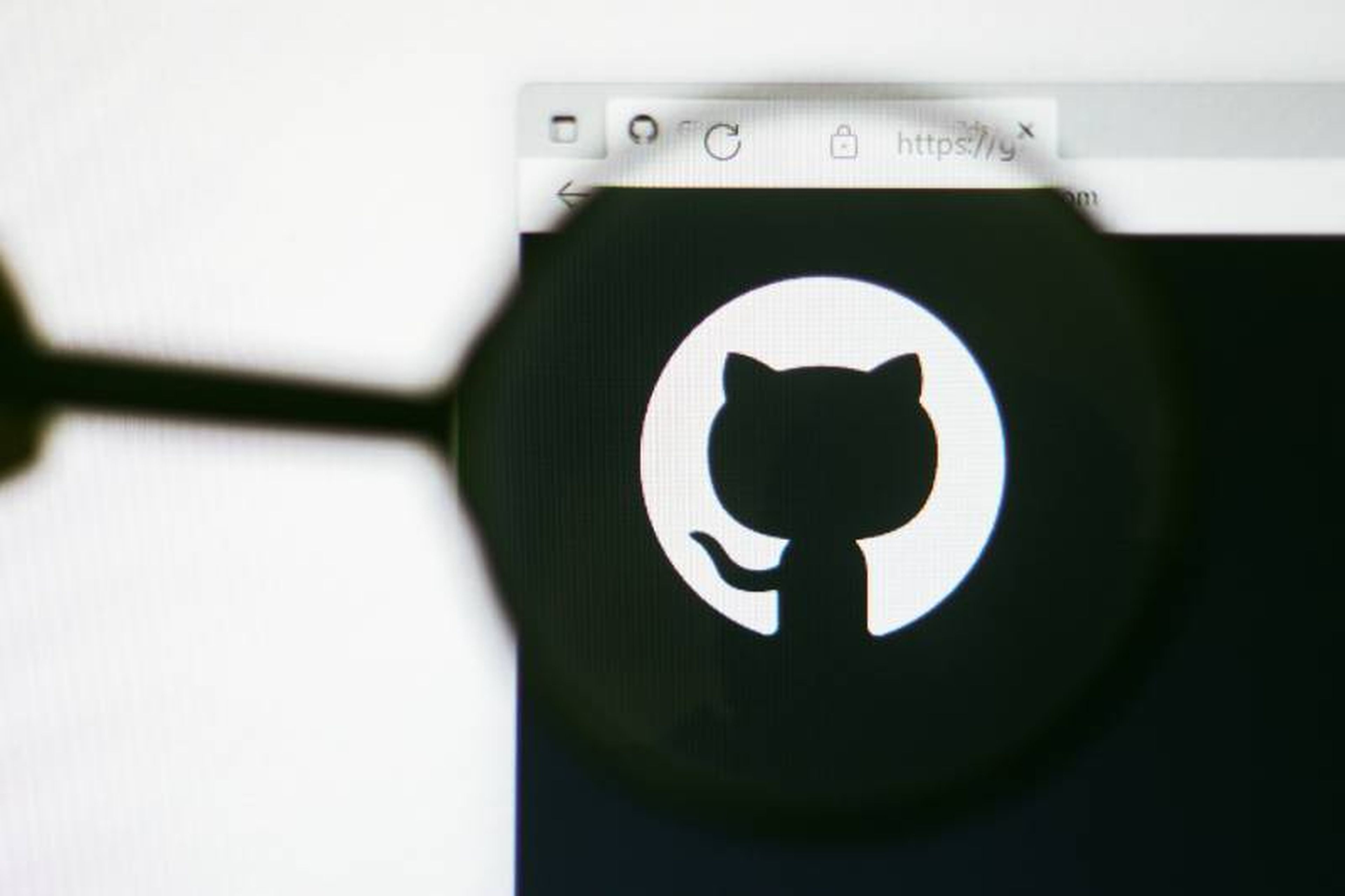 In this photo illustration, the homepage of the GitHub website seen on a computer screen through a magnifying glass.