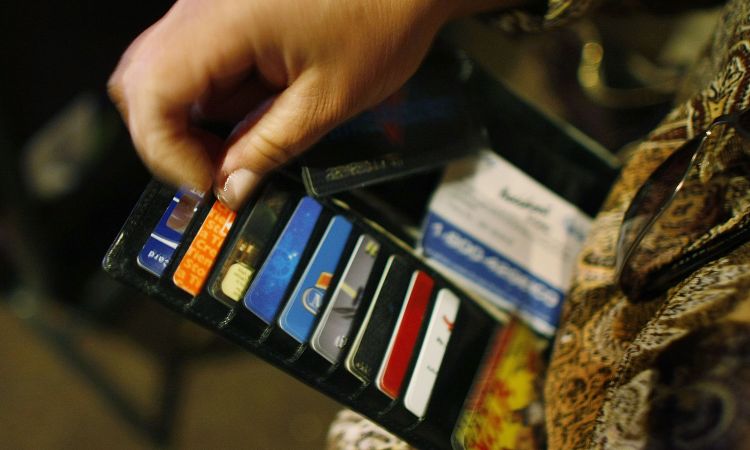 A woman looks in her wallet for credit cards.